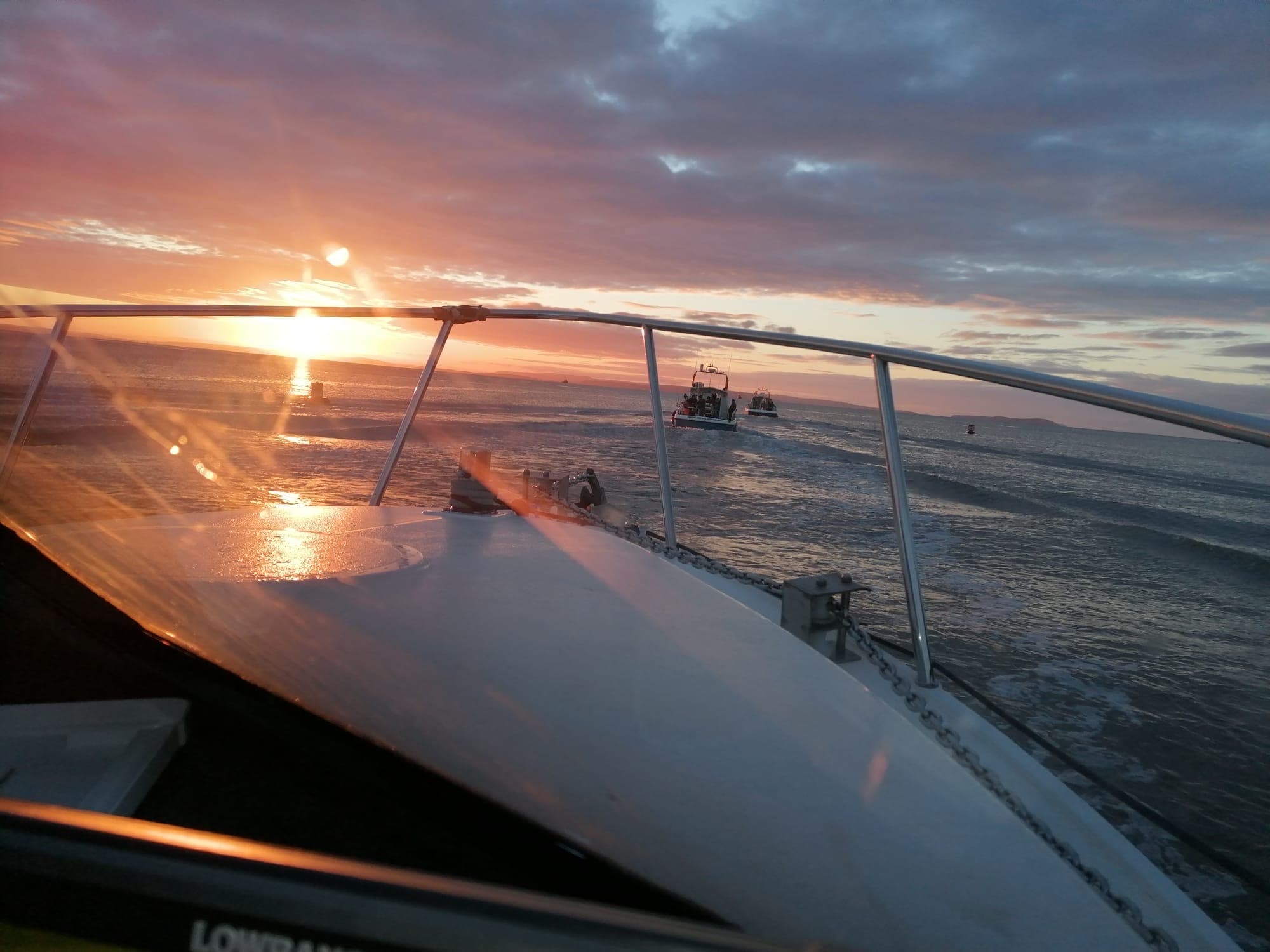 Charter boats heading out of Cardiff at sunrise