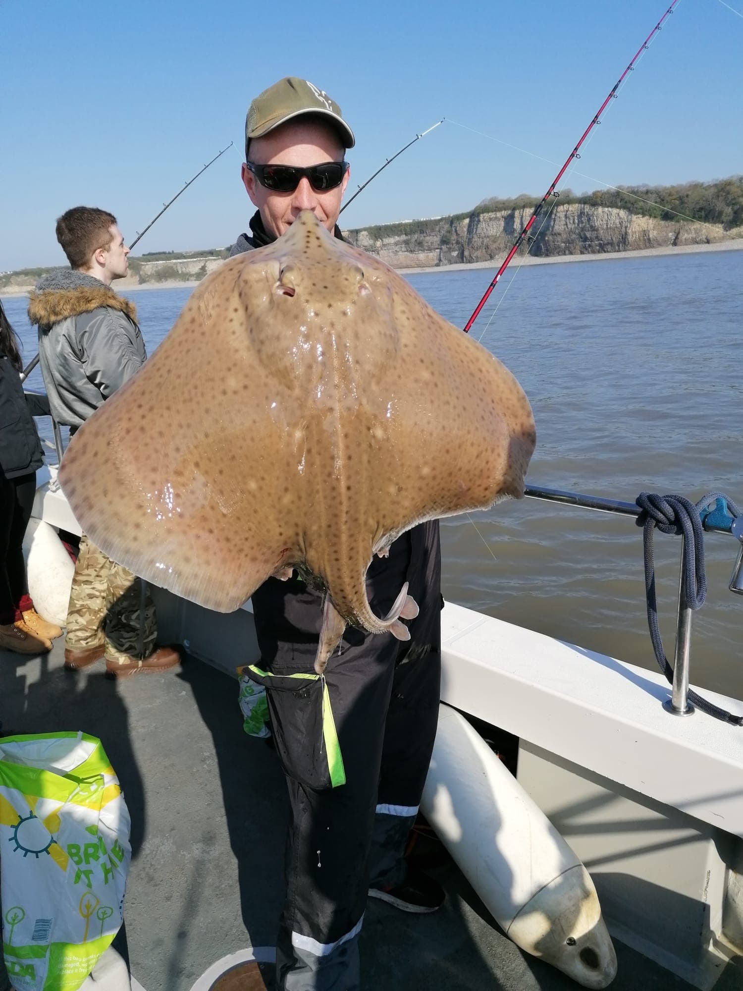 A specimen blonde ray held up on deck