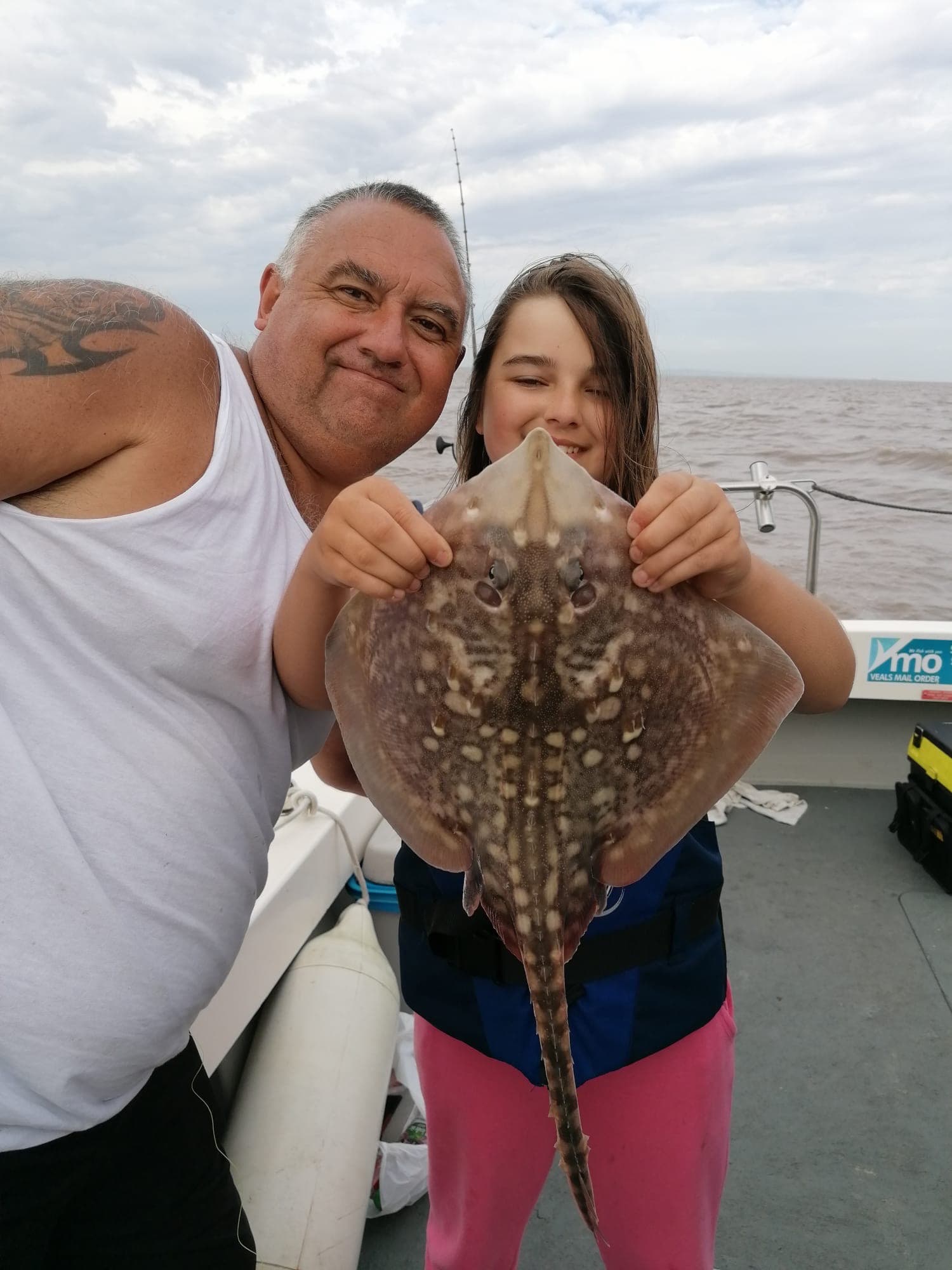 Father and daughter selfie with a thornback ray
