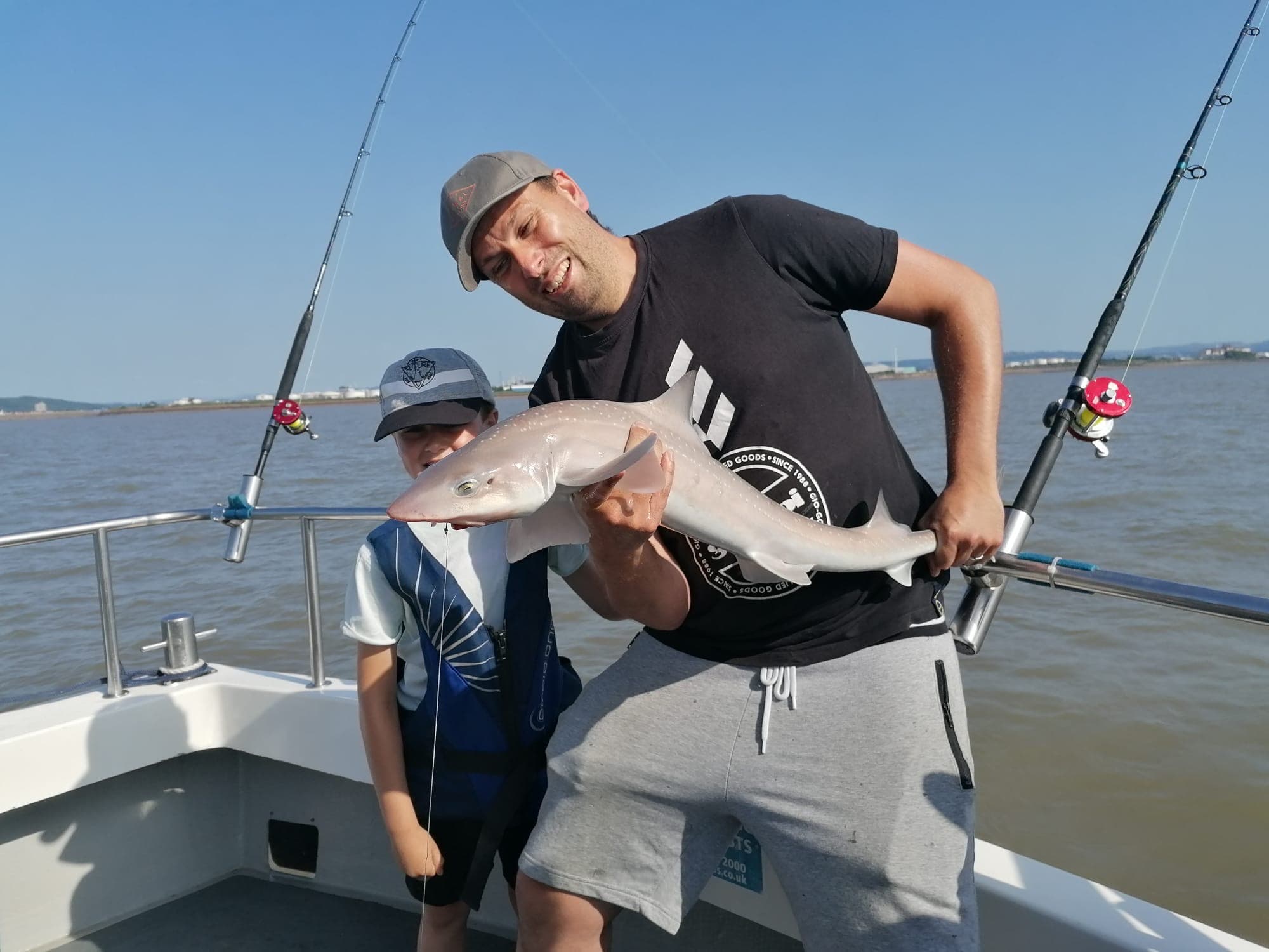Dad and son with a smooth-hound on a flat-calm summer day